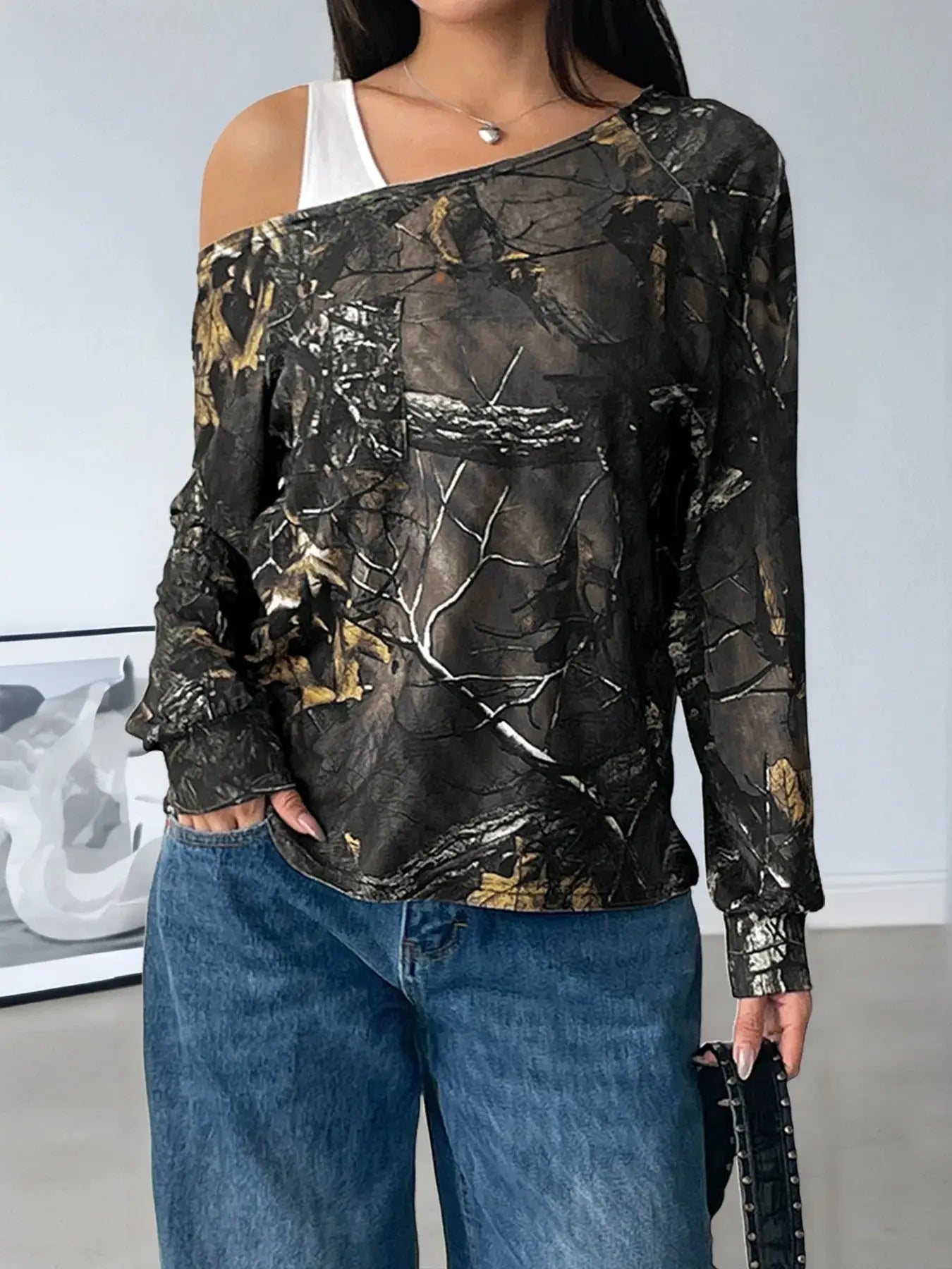 Asymmetrical long sleeve top with a camouflage print and cutout detail.