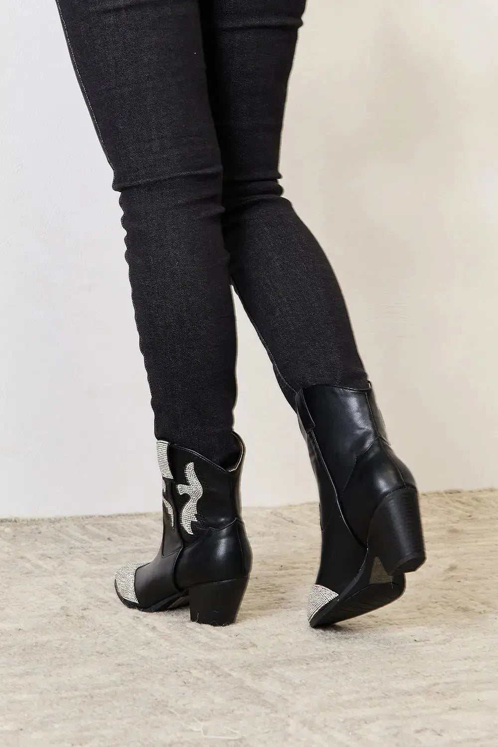 Black ankle boots with rhinestone accents and a pointed toe chunky heel.