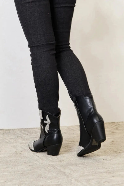 Black ankle boots with rhinestone accents and a pointed toe chunky heel.