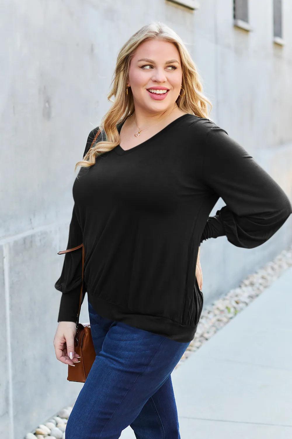 Black v-neck top with lantern sleeves and a cinched hem.