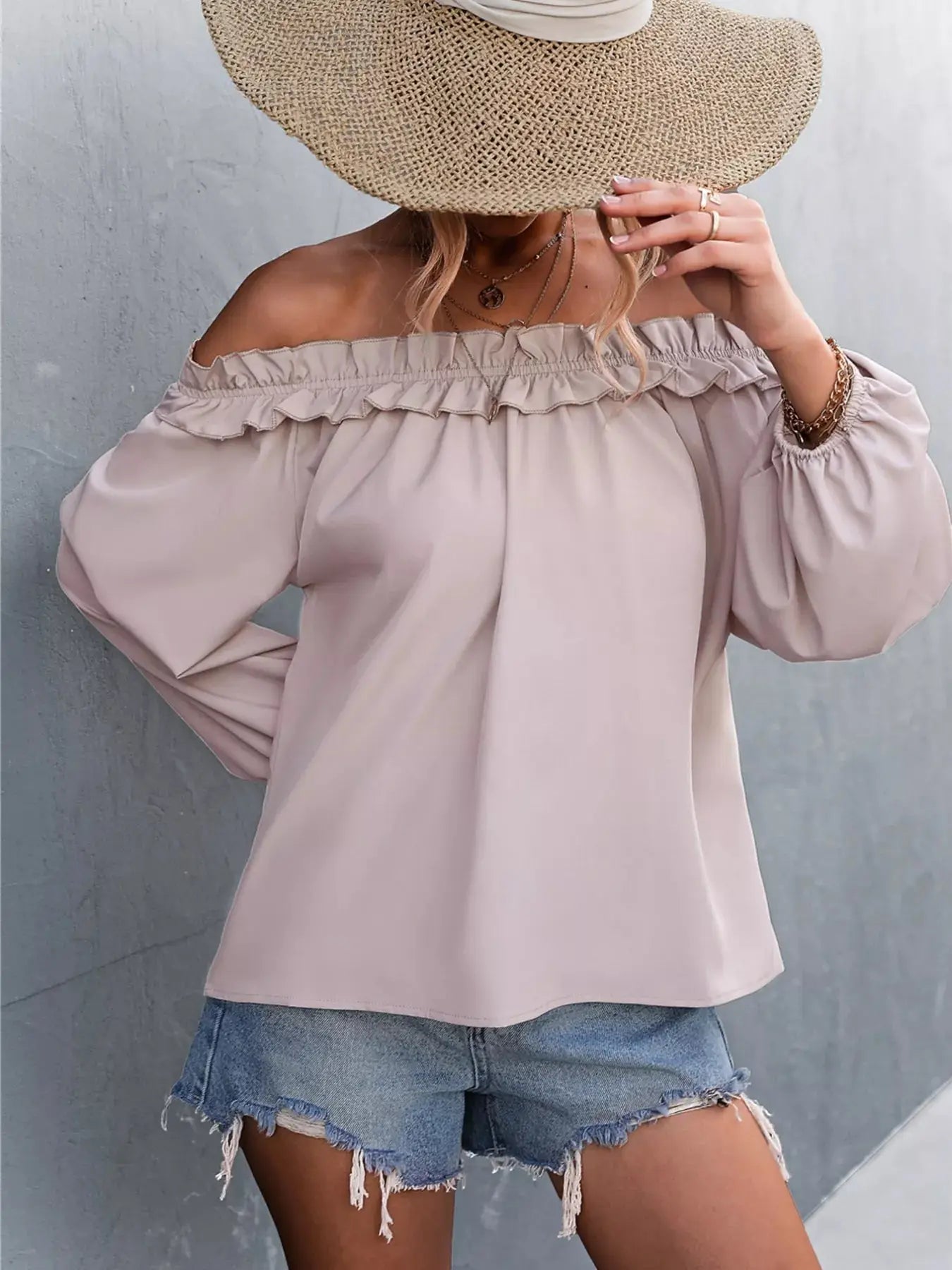 Off-shoulder long-sleeve blouse with ruffled neckline and balloon sleeves.