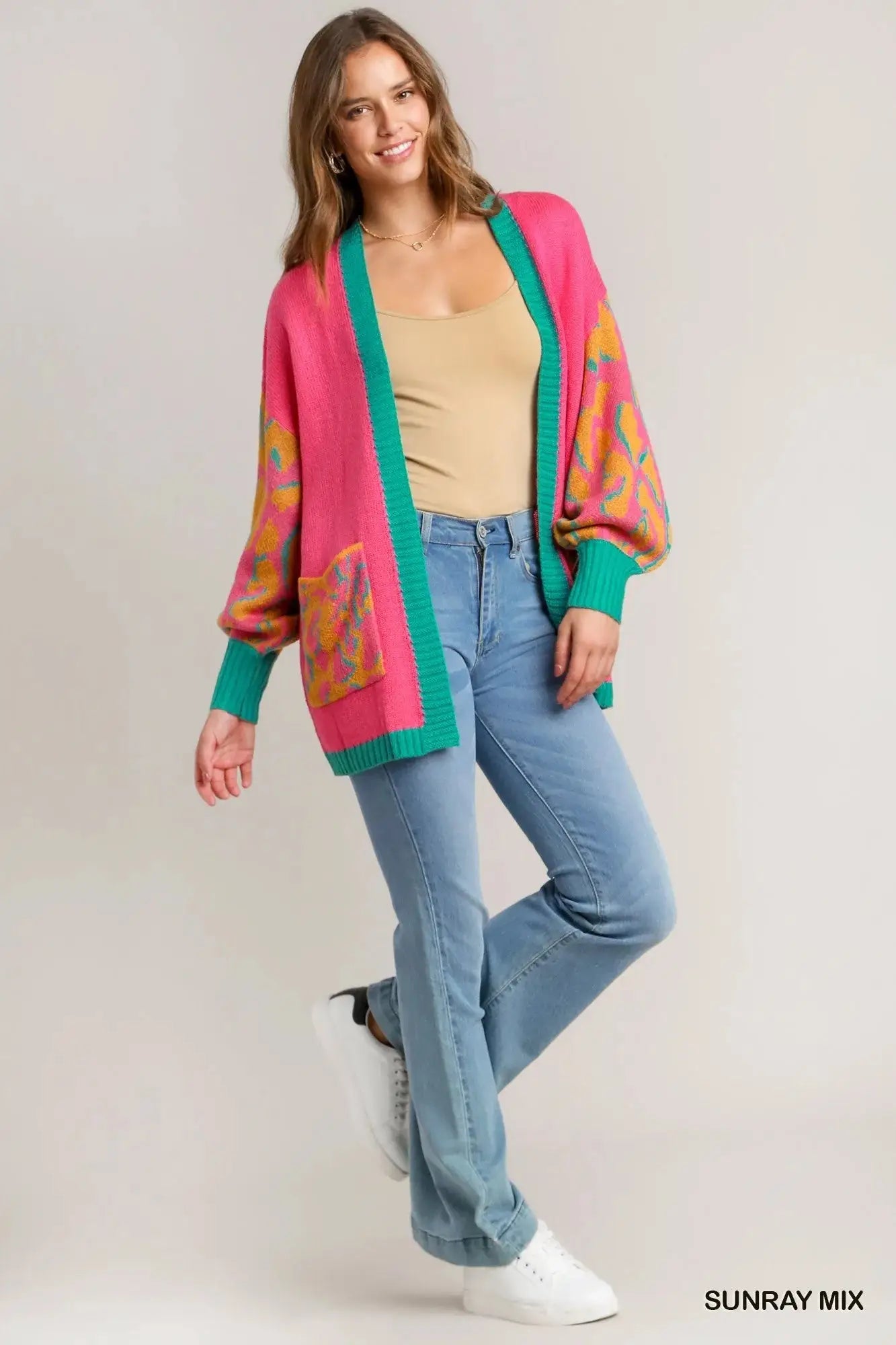 Woman wearing a pink and teal animal print oversized open front cardigan.