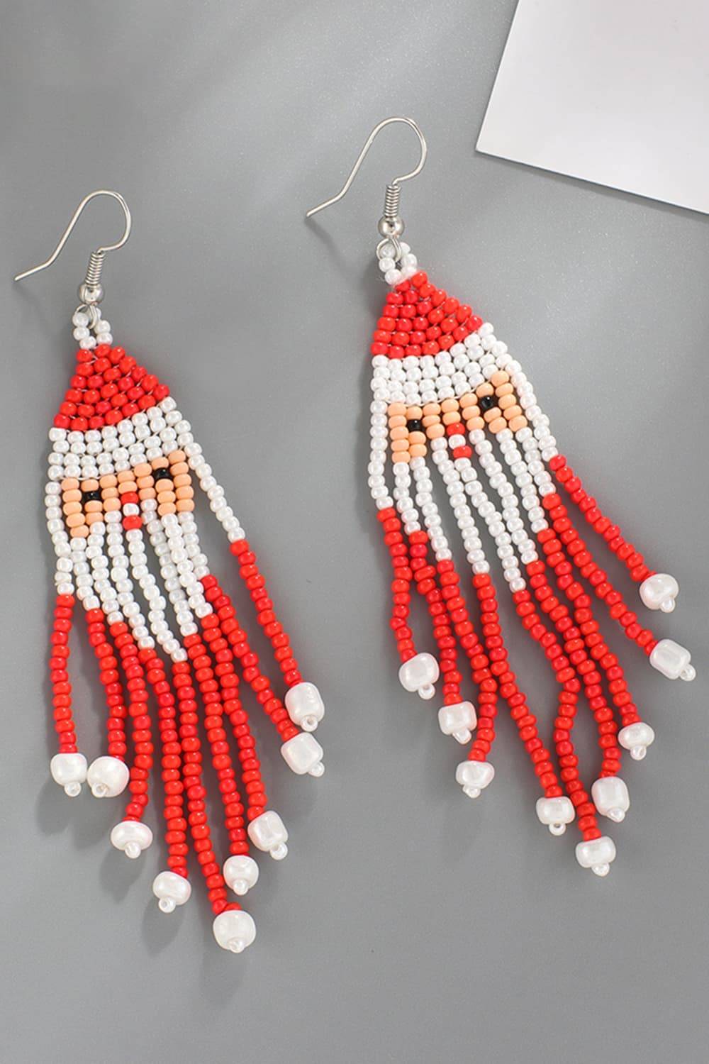 Handmade beaded Santa Claus earrings with red, white, and peach beads.