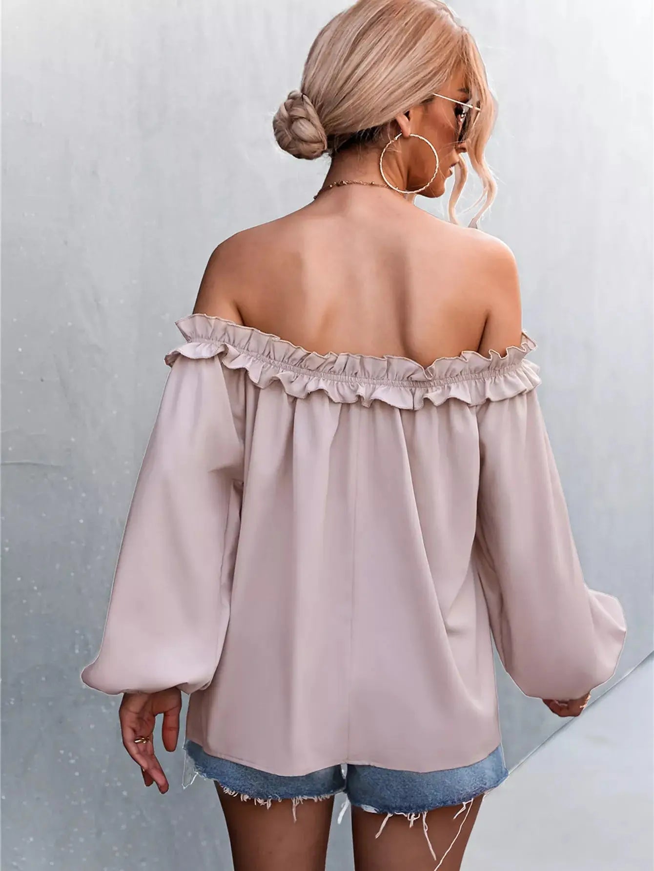Off-shoulder ruffled long sleeve blouse made of polyester blend.