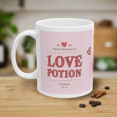 Love Potion ceramic mug with a pink background, featuring 'Cupid's Brewing Co' and 'Love Potion' text in red, perfect for Valentine's Day.