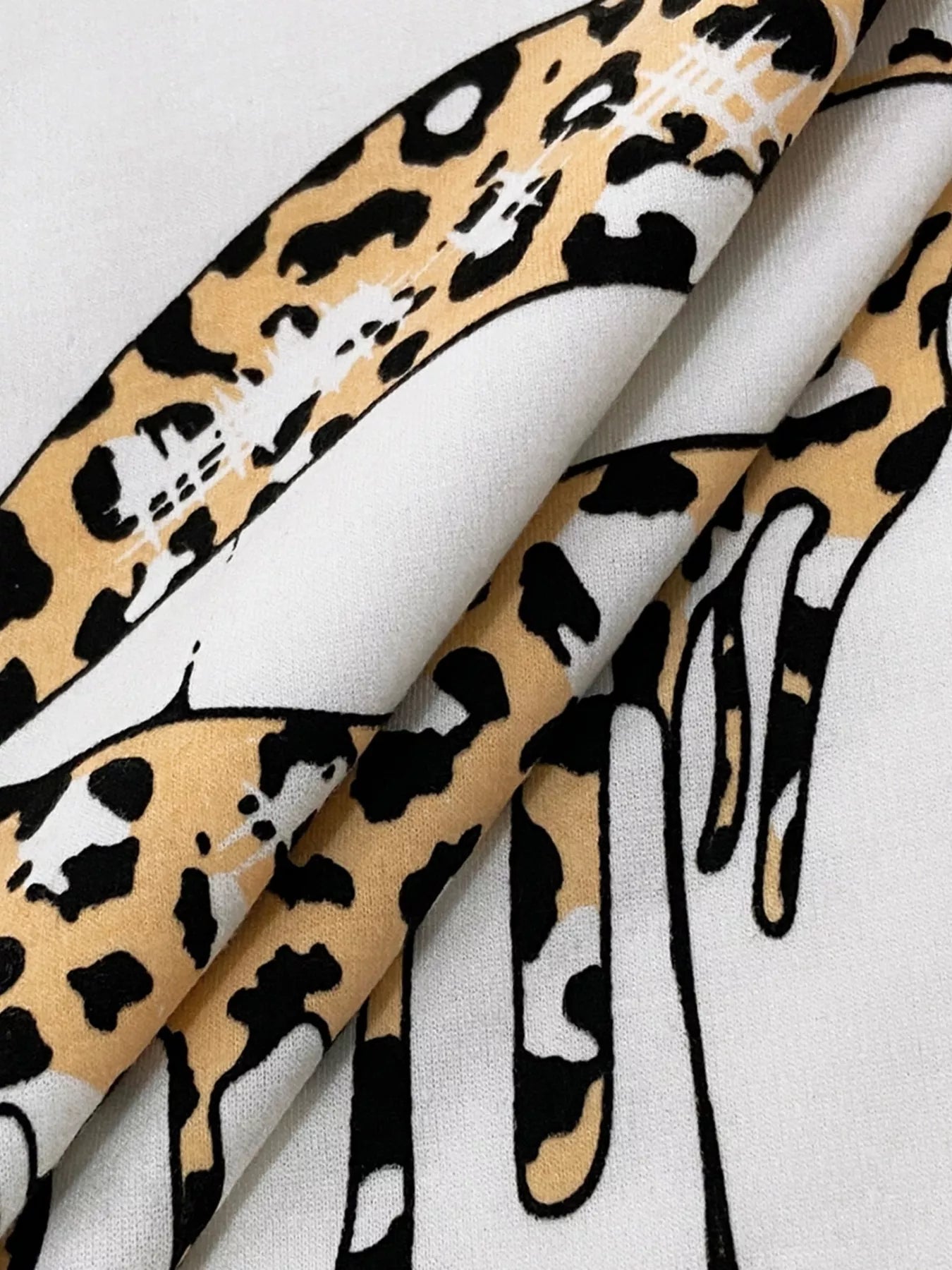 Graphic t-shirt with a white background and a leopard print design.