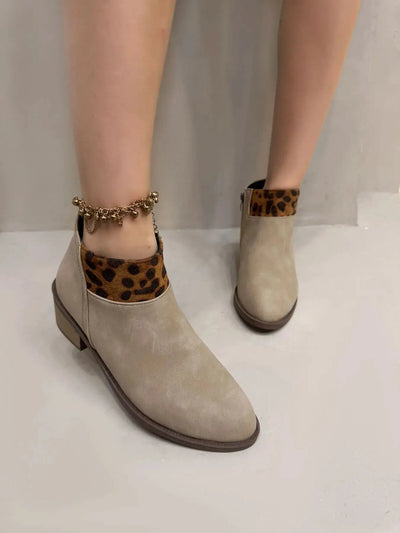 Beige suede ankle boots with leopard print trim and a gold anklet.