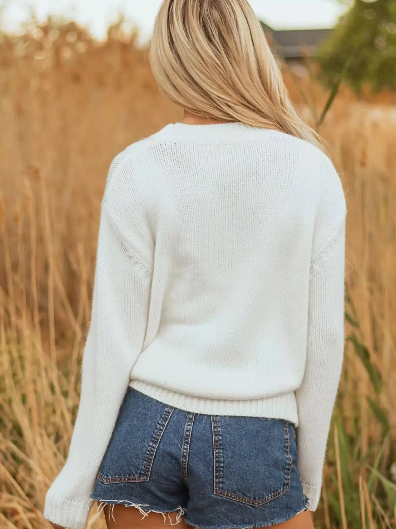 White embroidered drop shoulder sweater with denim shorts.