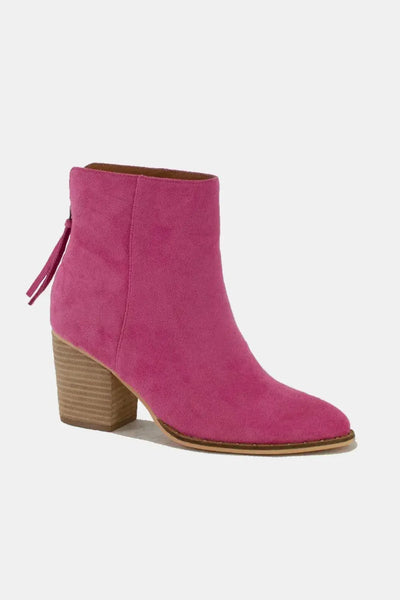 Pink suede pointed toe ankle booties with a stacked block heel and back tassel detail.